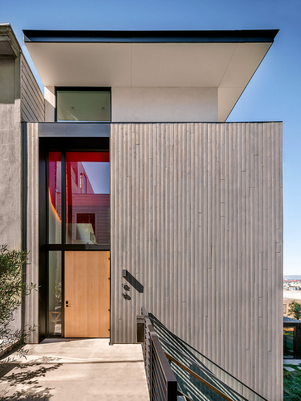 Sleek, modern facade with vertical wood paneling and a prominent roofline overhang.