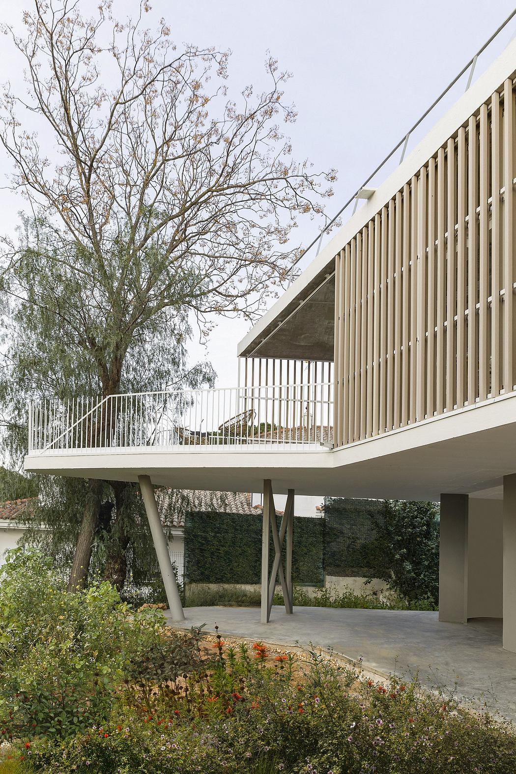 Elevated outdoor deck with wooden slatted railings, surrounded by lush greenery.