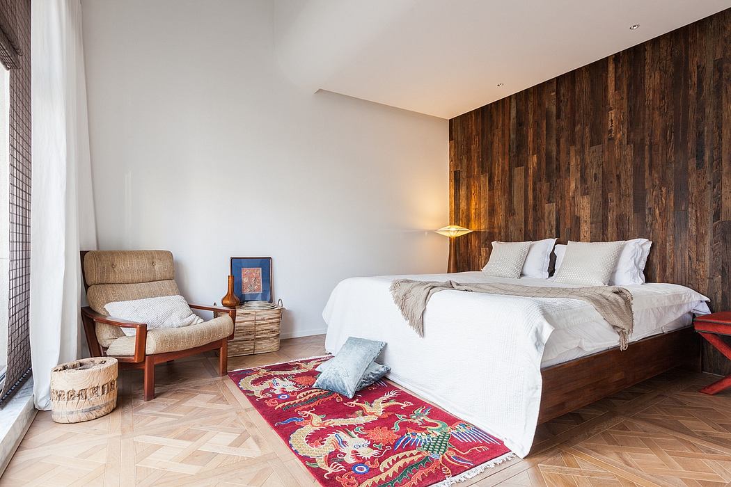 Cozy bedroom with rustic wooden wall paneling, plush rug, and mix of modern and traditional furnishings.