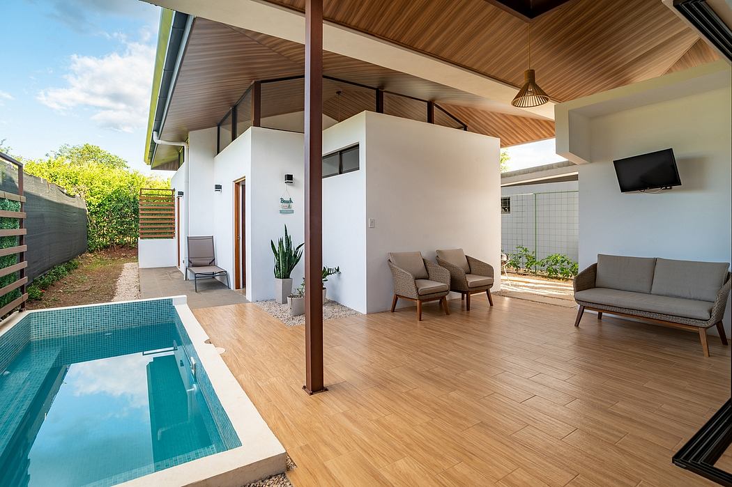 Inviting modern indoor-outdoor living space with a private pool, wood-paneled ceiling.