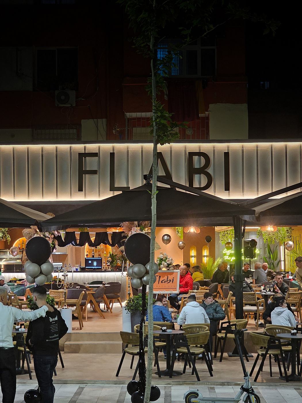 Brightly lit cafe with modern furniture, festive decor, and a striking outdoor sign.