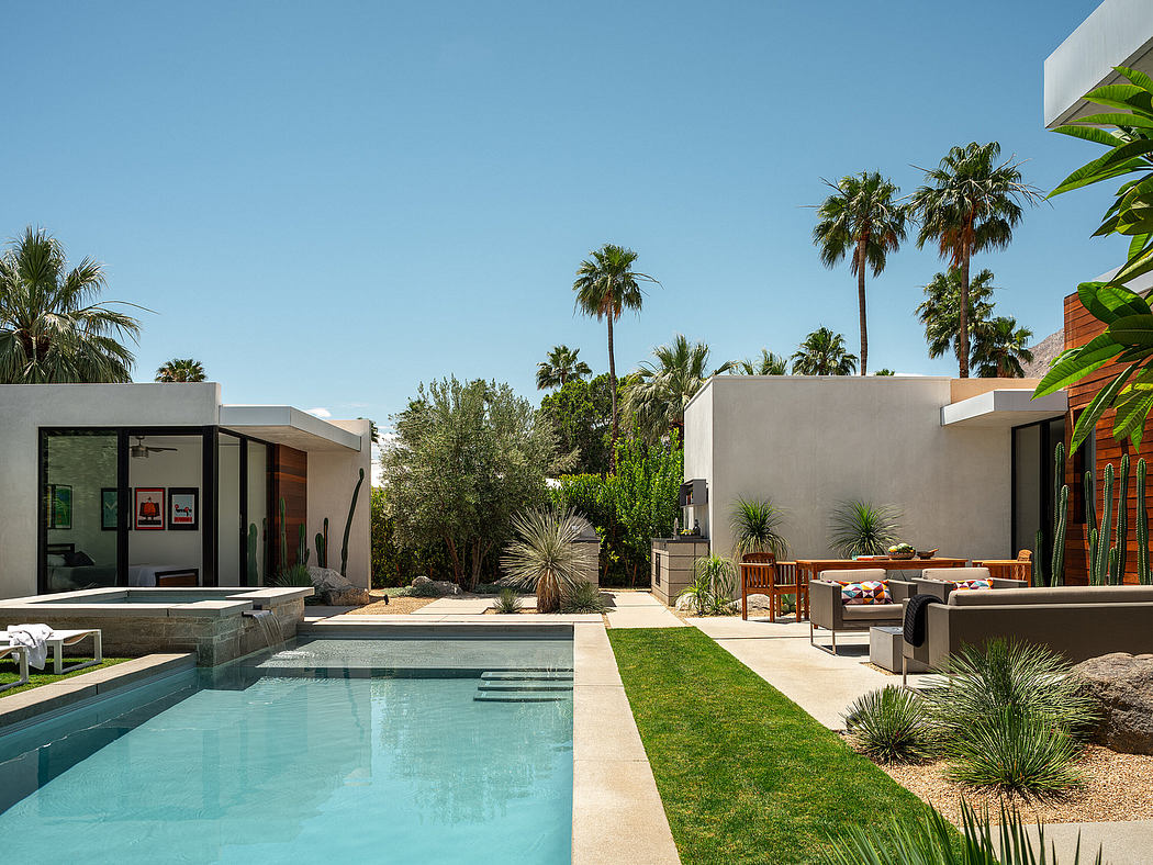 Contemporary residential outdoor oasis with pool, palm trees, and modern furnishings.