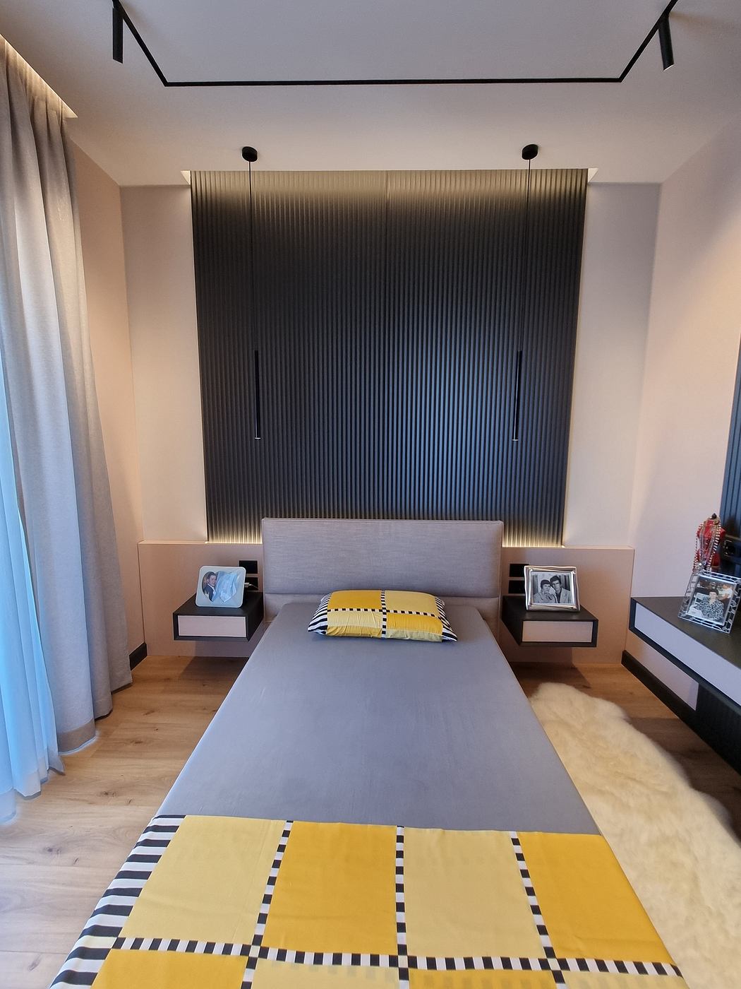 A modern bedroom with a striking black and white striped accent wall, creating a bold, geometric visual interest.