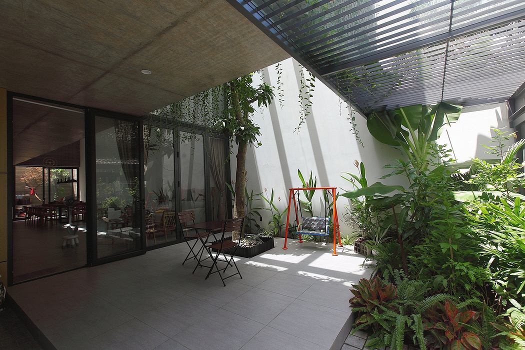 A contemporary indoor garden with lush greenery, glass walls, and modern seating.