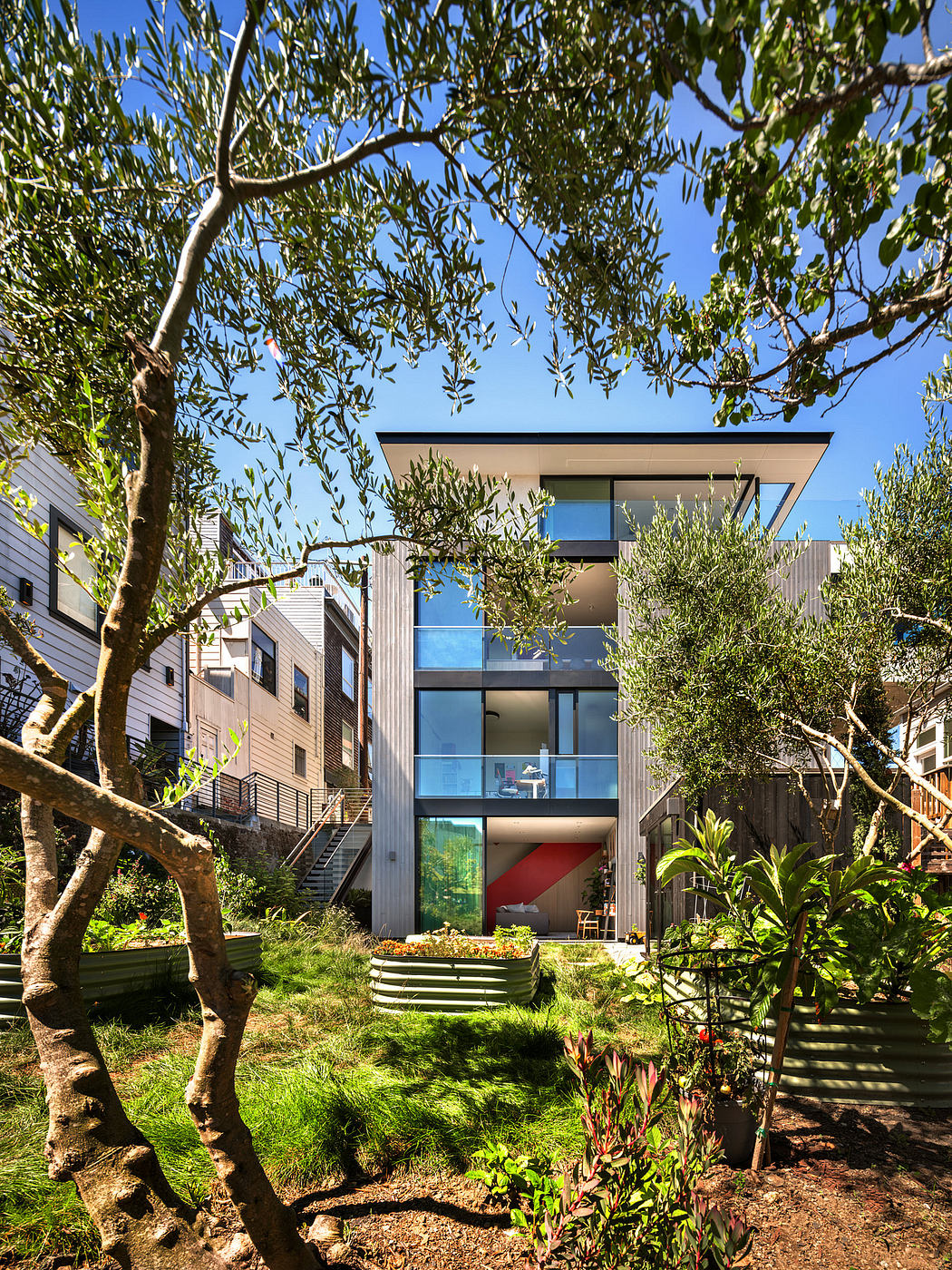 Striking modern home nestled among lush greenery, with sleek glass walls and architectural details.