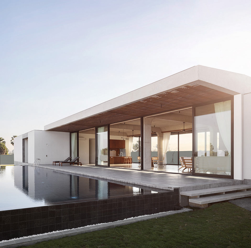 Sleek, modern house with expansive glass walls, wooden canopy, and reflecting pool.