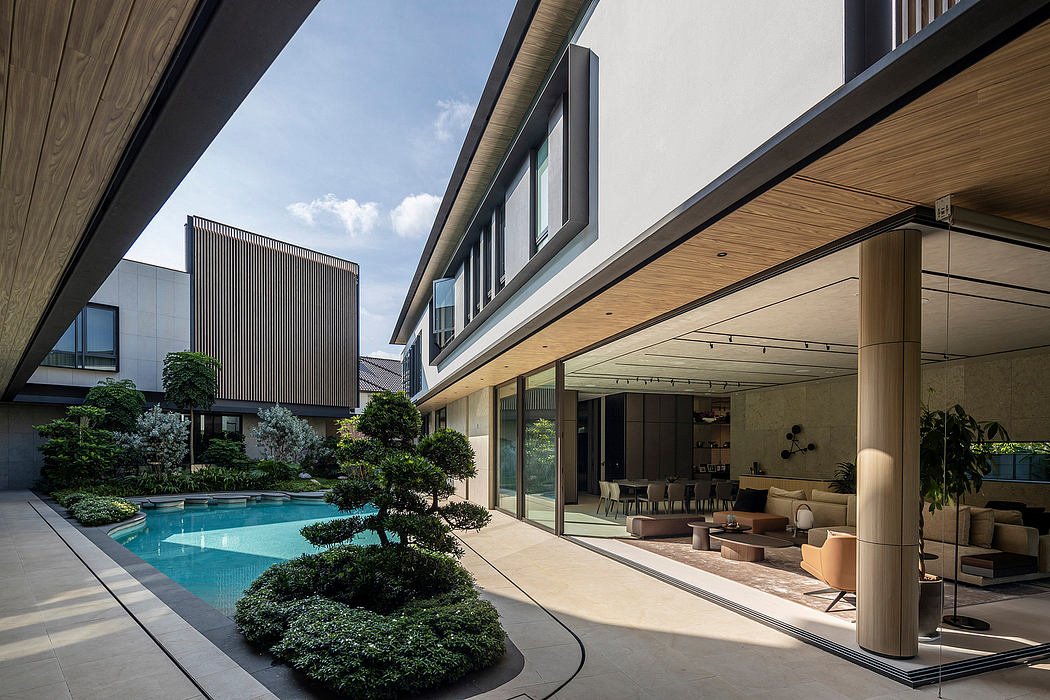 Sleek modern architecture with pool, greenery, and cozy lounge area.