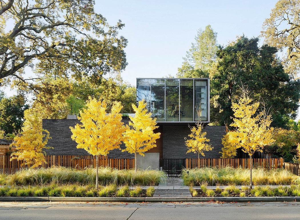 A modern architectural structure with glass walls surrounded by vibrant autumn trees.