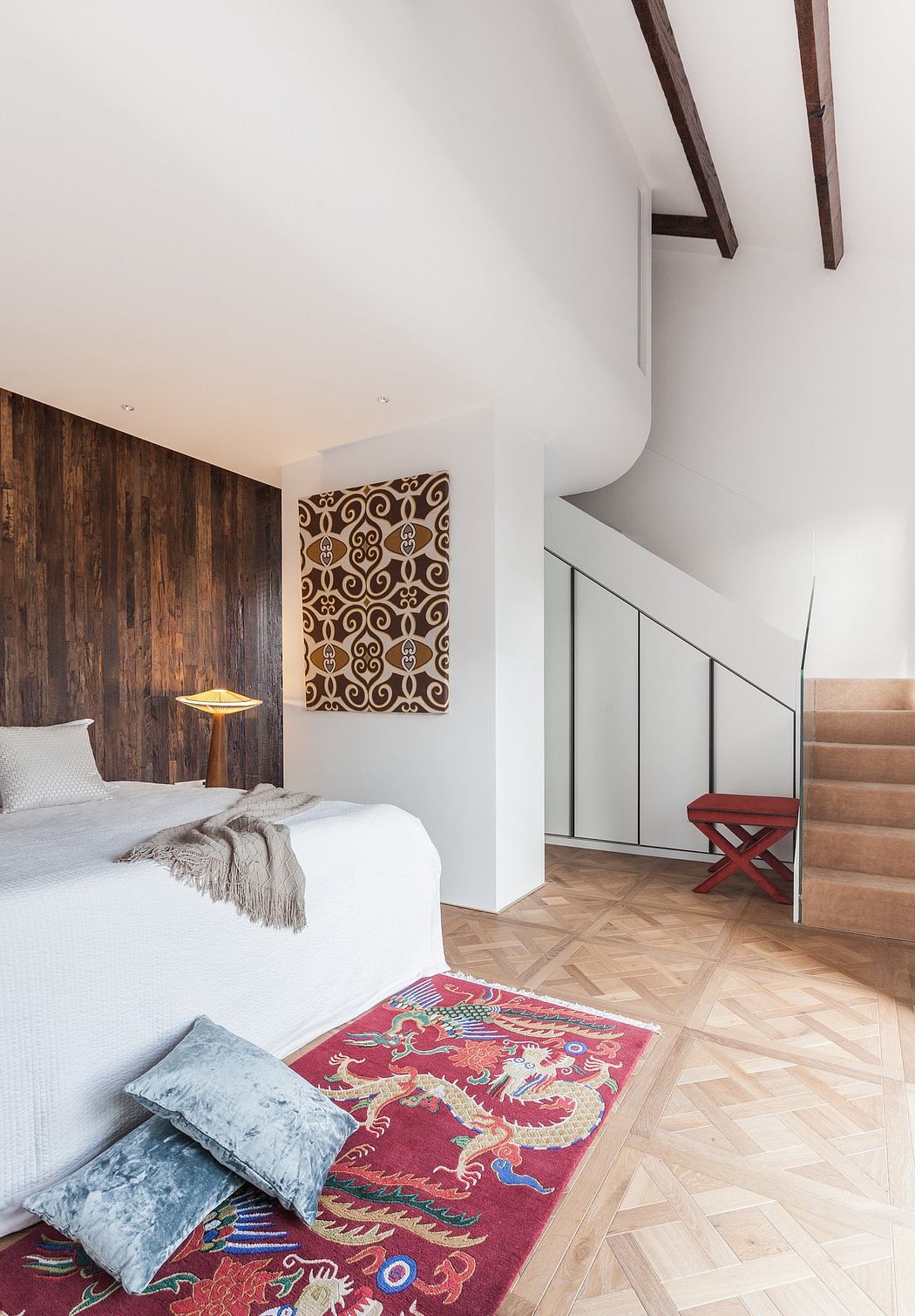 Modern rustic bedroom with exposed wooden beams, patterned rug, and minimalist decor.