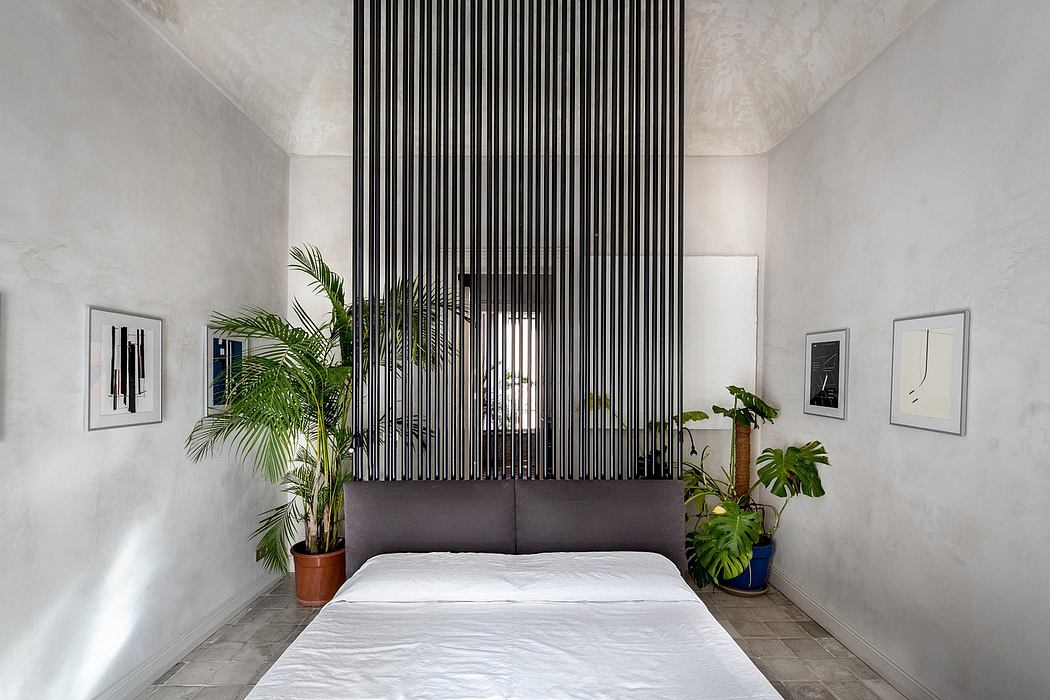 A modern bedroom with a bold vertical slat wall as the centerpiece, accented by lush plants.