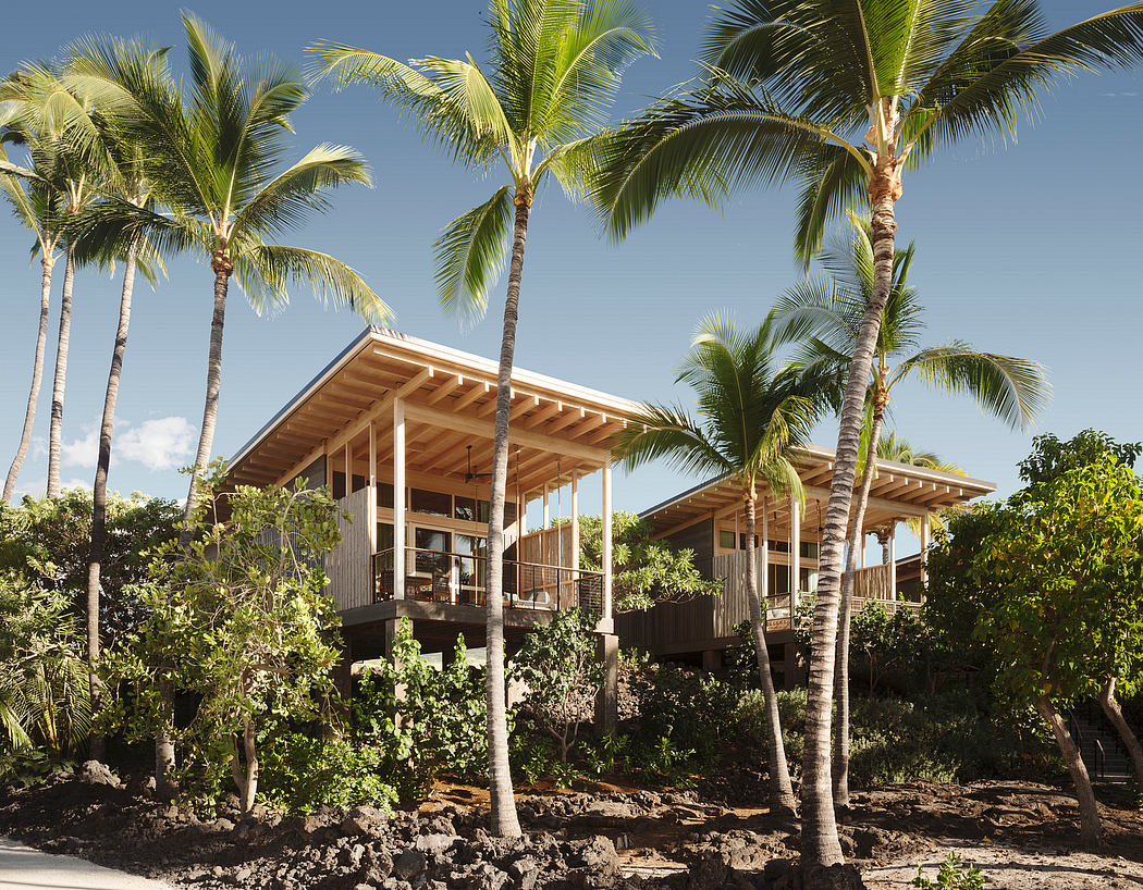 Striking wooden bungalow nestled among lush palm trees, with open-air design and elevated deck.