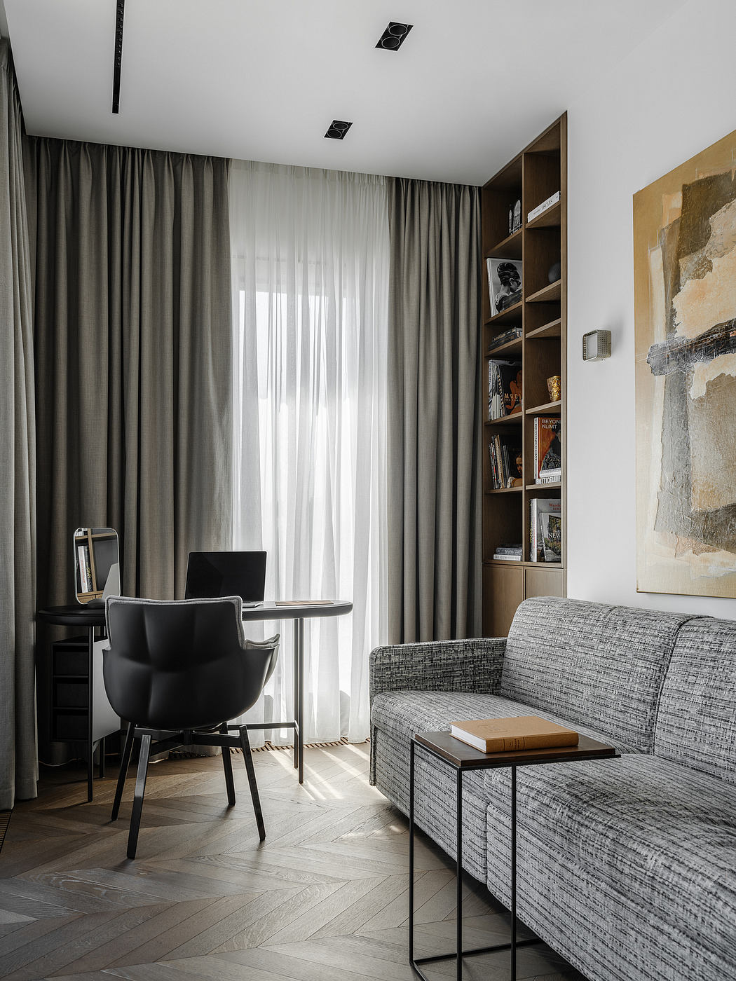 Refined living space with sleek furniture, moody lighting, and a built-in shelving unit.