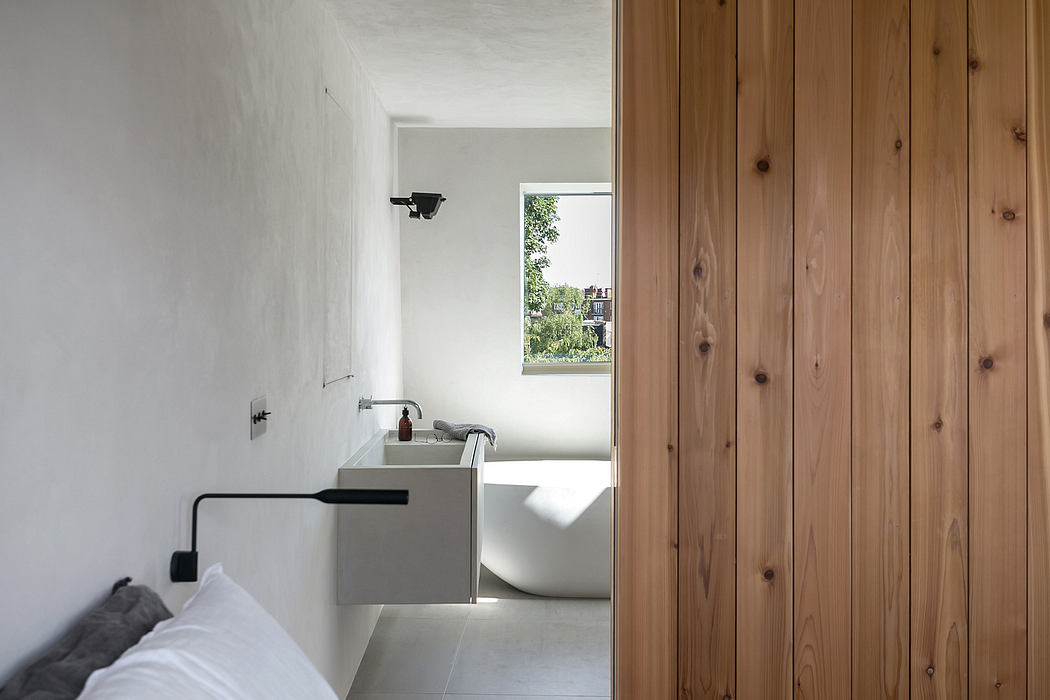 Modern bathroom with white walls, wooden paneling, and a freestanding bathtub.