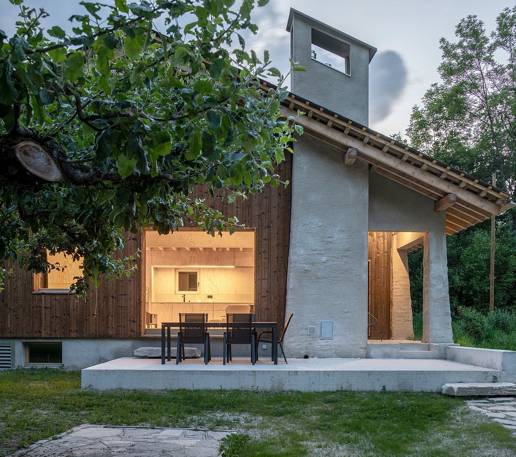 A rustic outdoor patio with wooden accents, a concrete platform, and a towering chimney.