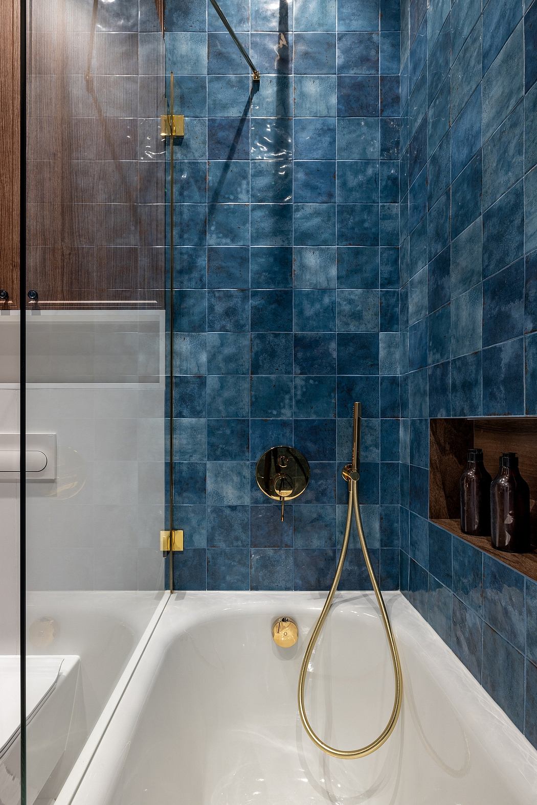 Modern bathroom with blue marble tiles, gold fixtures, and sleek design elements.