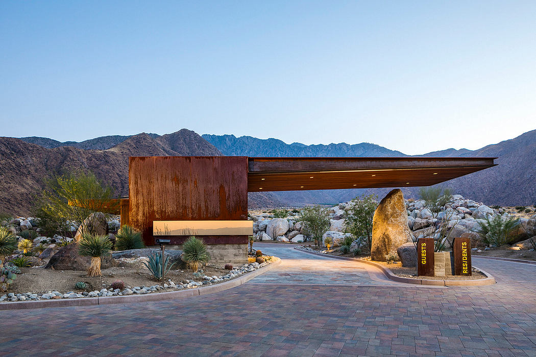 Modern desert architectural entry with stone, wood, and lighting elements against mountainous backdrop.