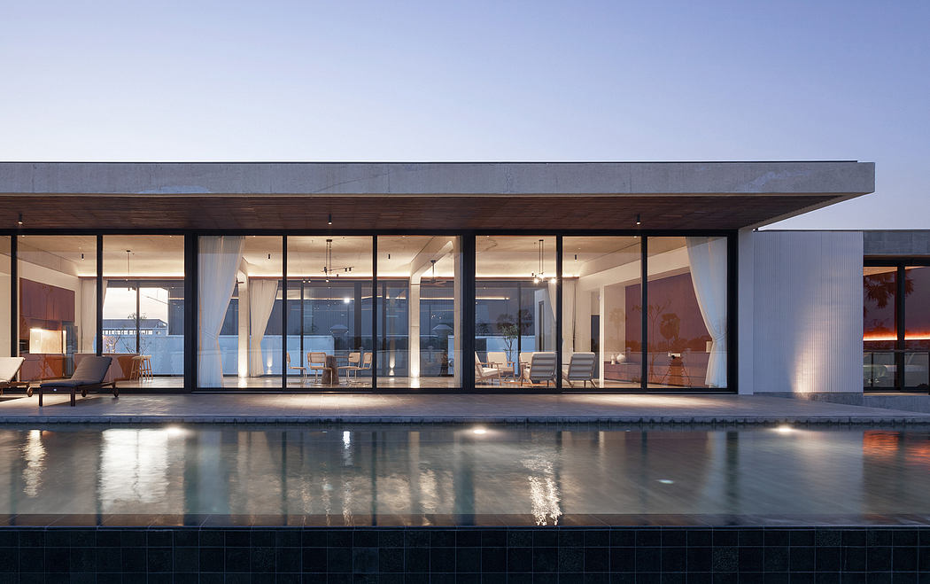 Modern home with expansive glass walls, wooden canopy, and a reflective pool.