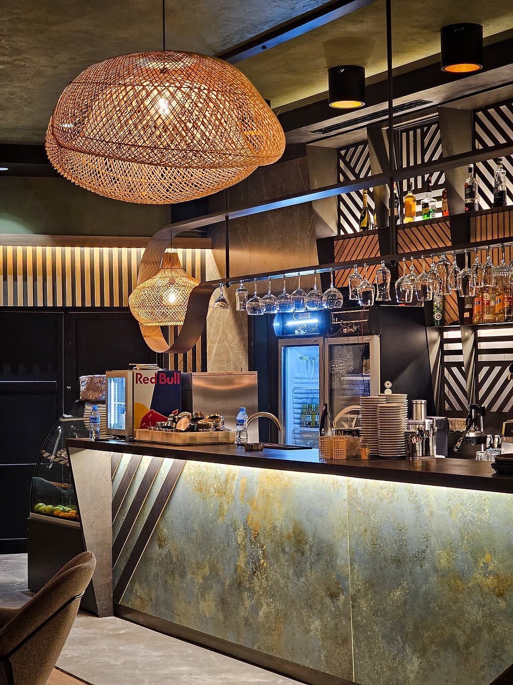 Cozy coffee shop interior with woven light fixtures, metal countertops, and industrial decor.