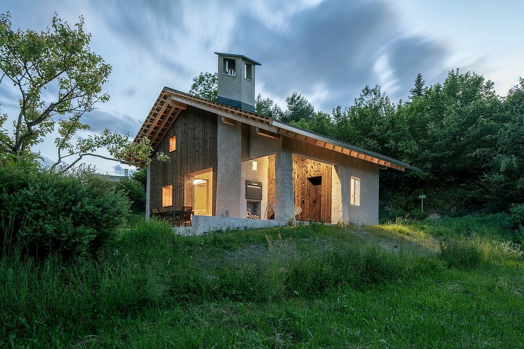 Rustic cabin nestled in lush greenery, featuring wooden construction and a chimney.