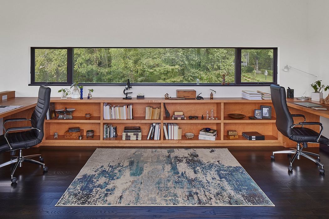 Expansive wooden shelves, minimalist desk setup, and large windows overlooking lush greenery.