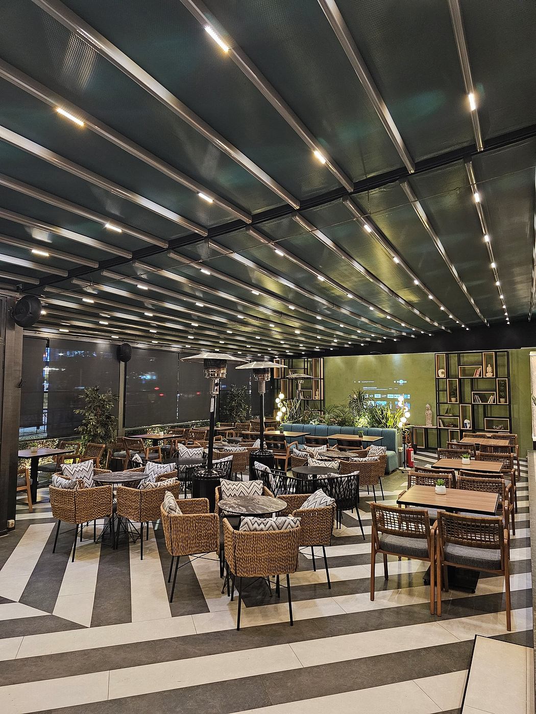 Moody, minimalist interior with geometric patterns, woven furniture, and recessed lighting.