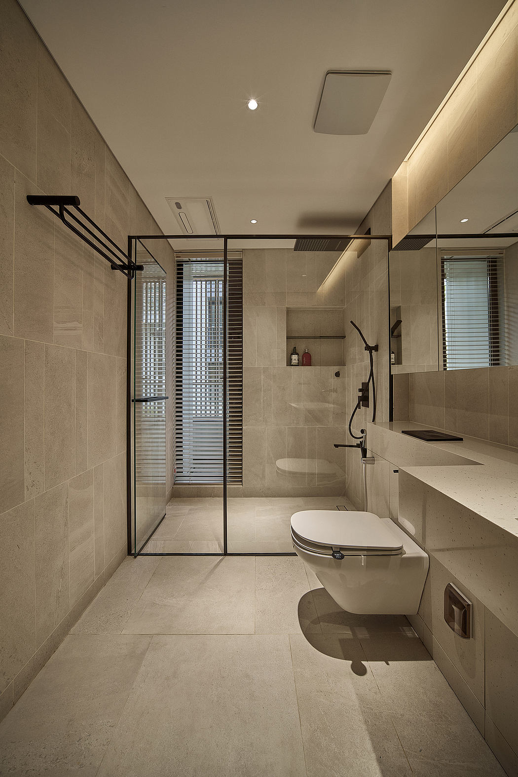 Sleek, modern bathroom with minimalist design and neutral tones, featuring glass shower enclosure.