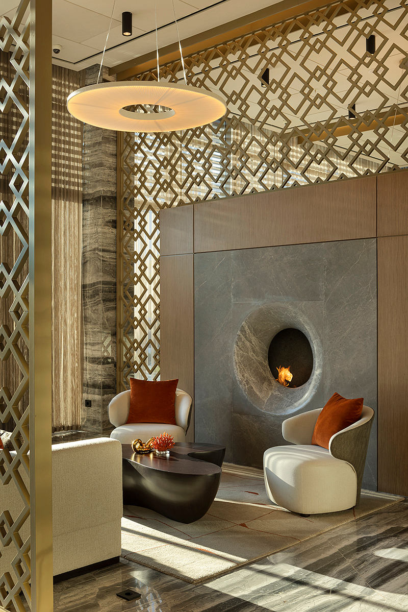 Elegant modern lobby with intricate lattice pattern, stone fireplace, and plush seating.