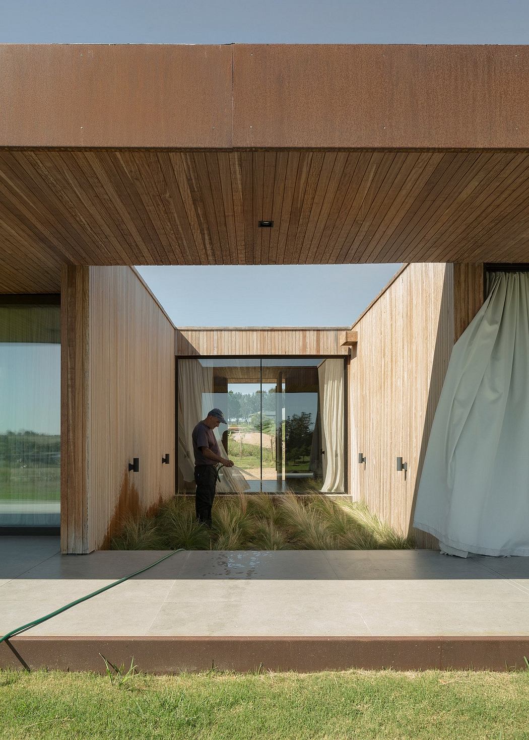 Wooden and glass modern architecture with tall ceilings, open layout, and surrounding nature.