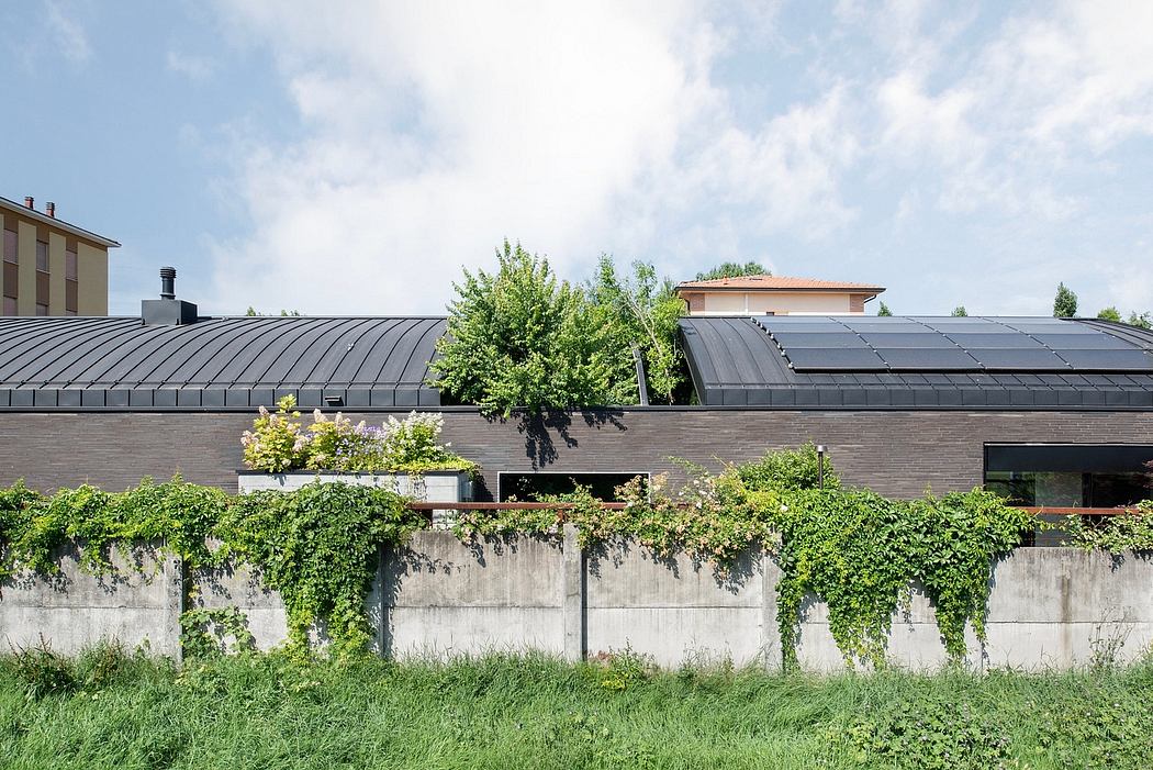 Modern architectural design with metal roofing, greenery, and solar panels.