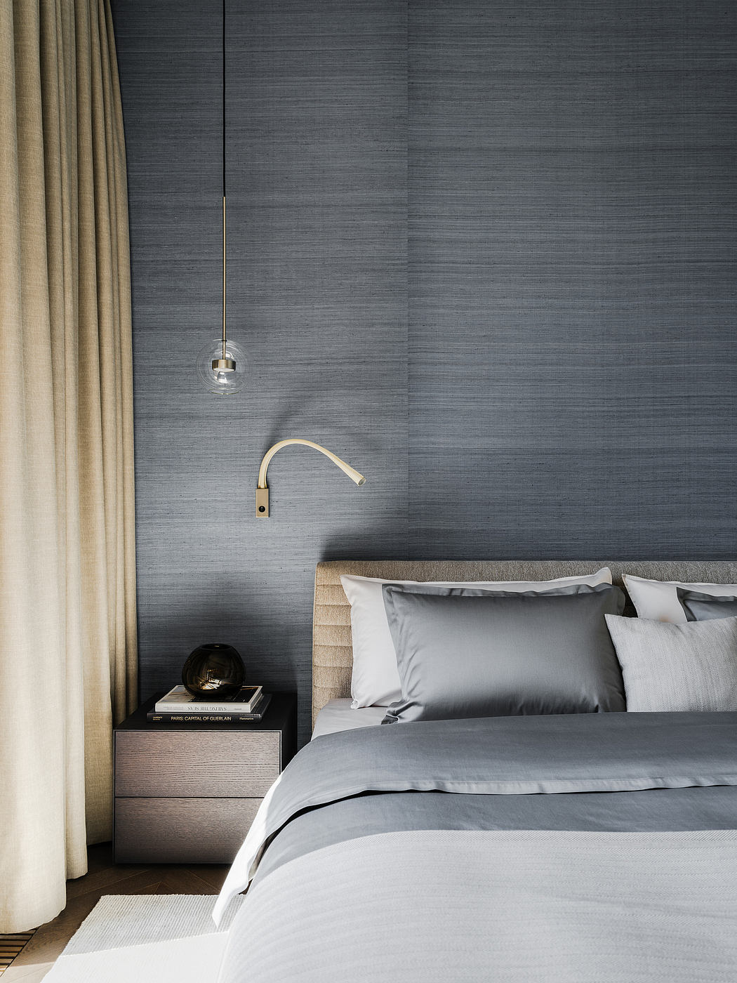 Minimalist bedroom with neutral bedding, pendant light, and textured gray walls.