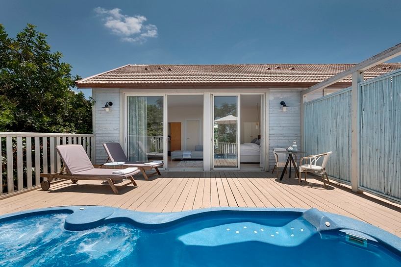 Modern outdoor deck with a private swimming pool, loungers, and sliding glass doors leading to the interior.