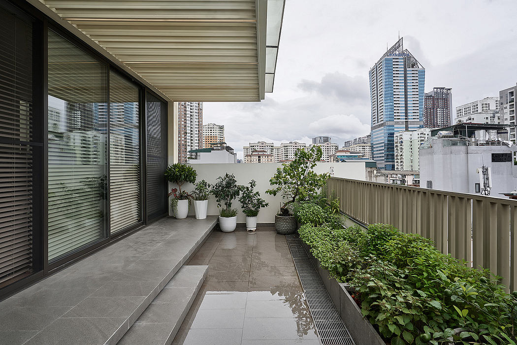 Minimalist balcony with potted plants, glass walls, and a view of the city skyline.