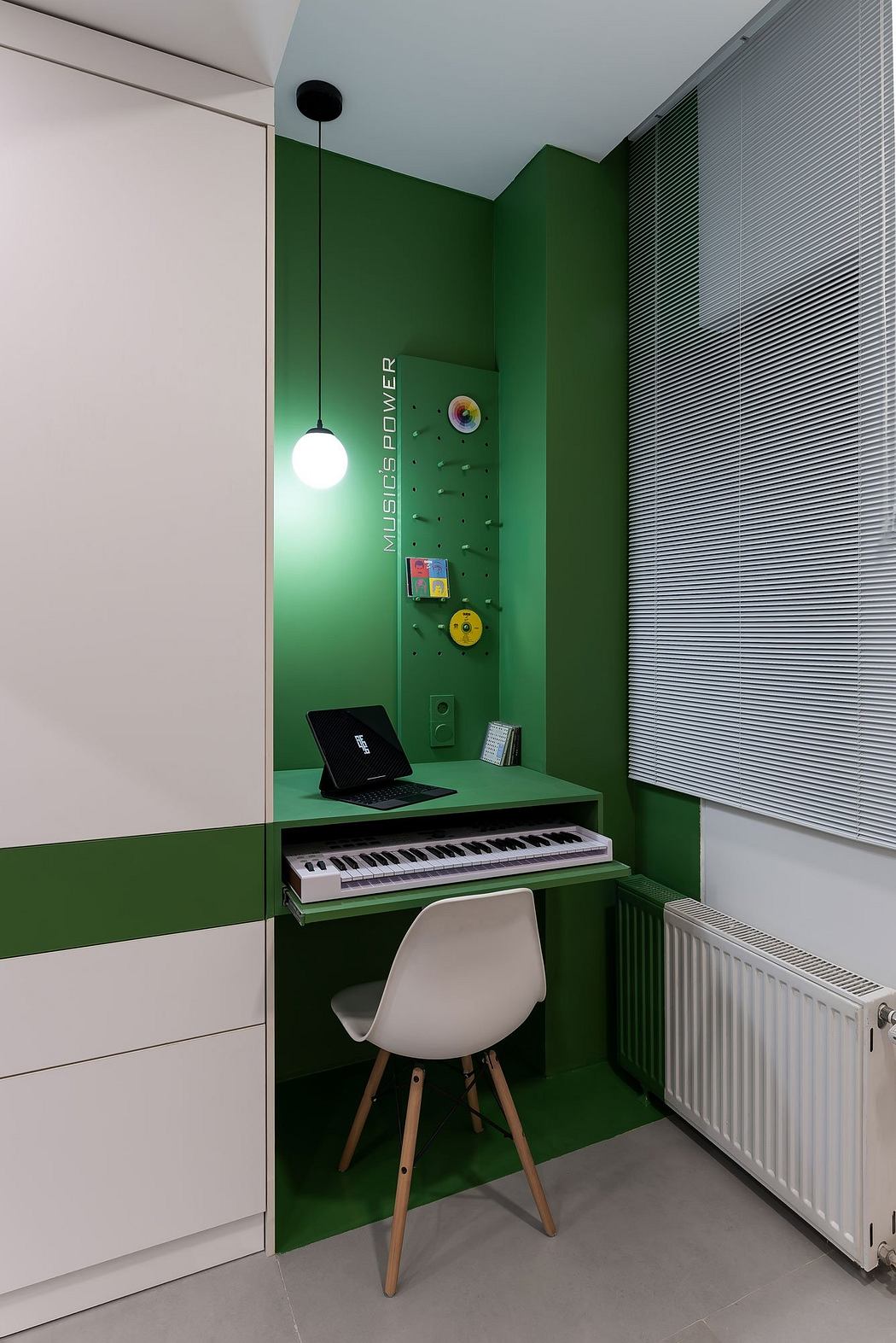 A compact, bright green workspace with a white chair, laptop, and musical keyboard.
