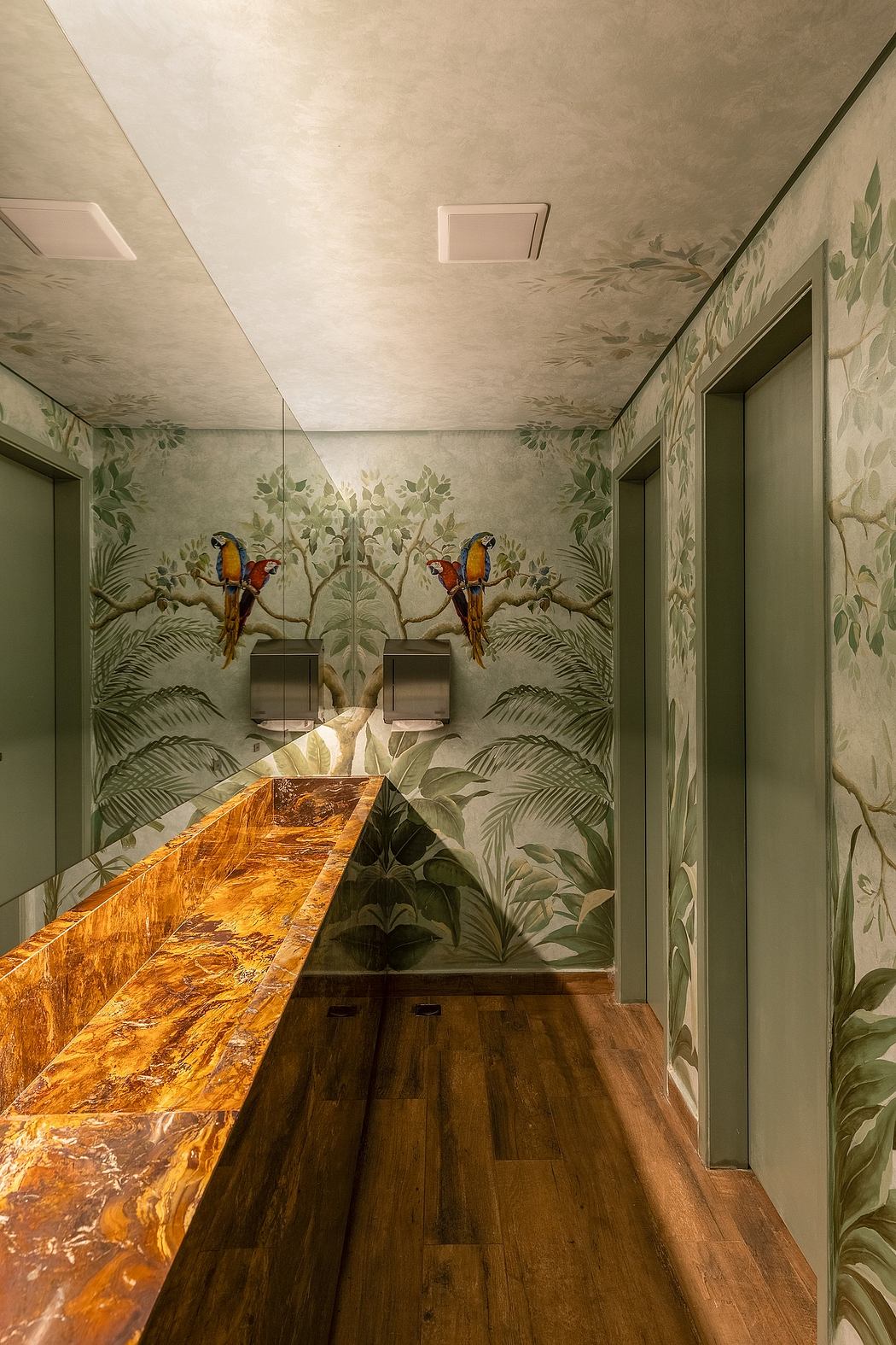 A vibrant tropical-themed restroom with a striking wooden vanity and lush painted walls.