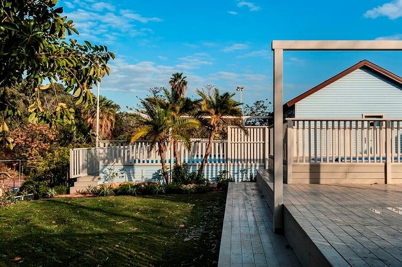 Cozy coastal home with wooden deck, palm trees, and inviting outdoor space.