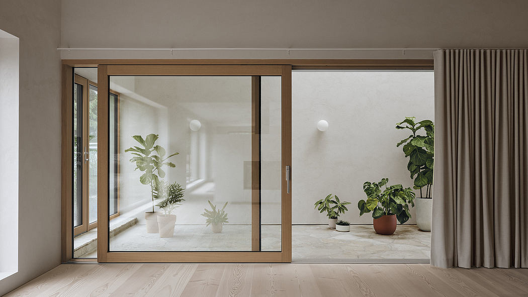 Minimalist interior with wooden sliding doors, potted plants, and natural light.
