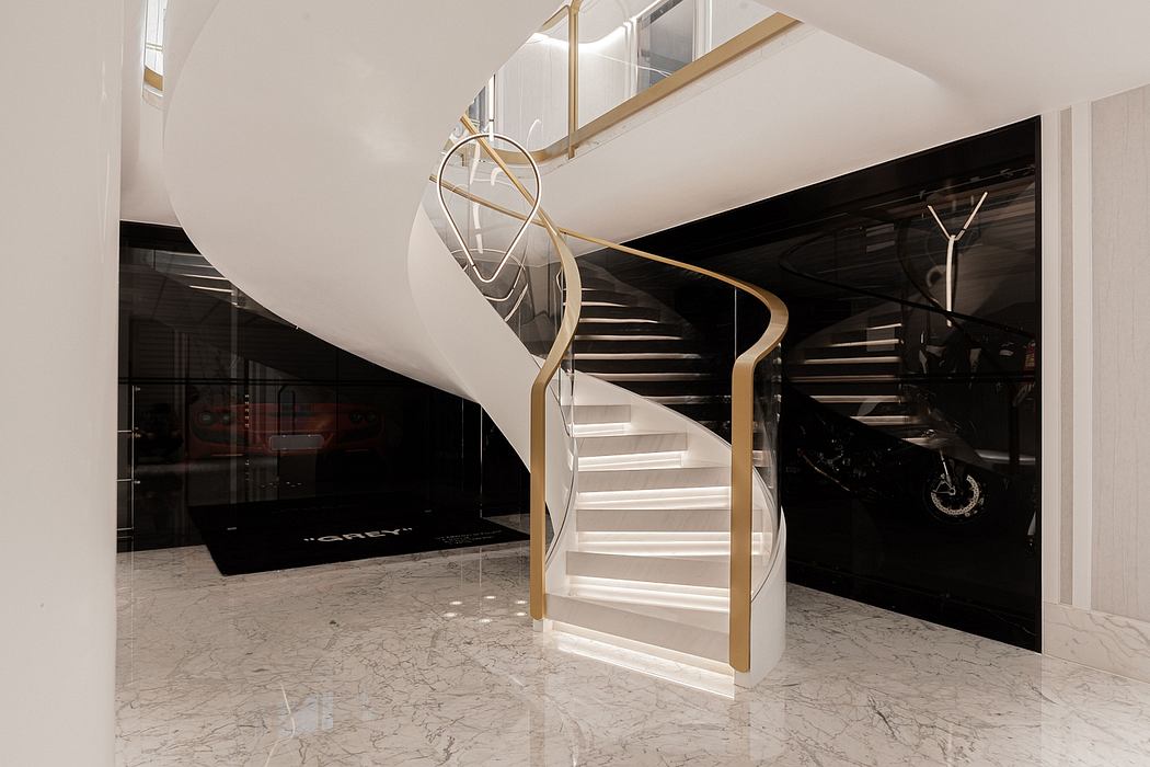 Sleek, modern staircase with curved metallic railing, set against a black and white marble backdrop.