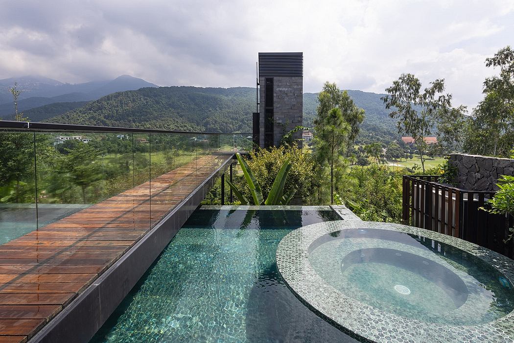 A modern, minimalist outdoor pool area with a scenic mountain backdrop and glass walls.
