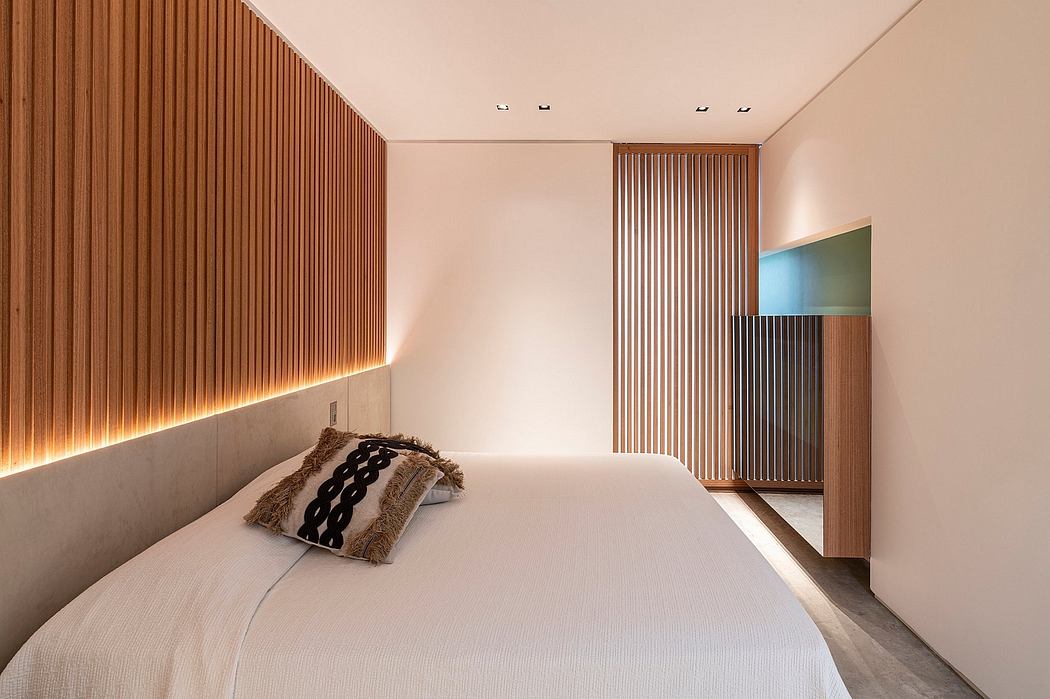 Minimalist bedroom with warm wood paneling, recessed lighting, and a modern decor.