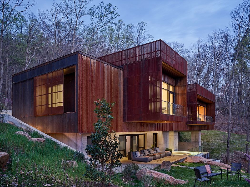 Modern cabin-style home with rustic wood exterior, large windows, and inviting outdoor patio.