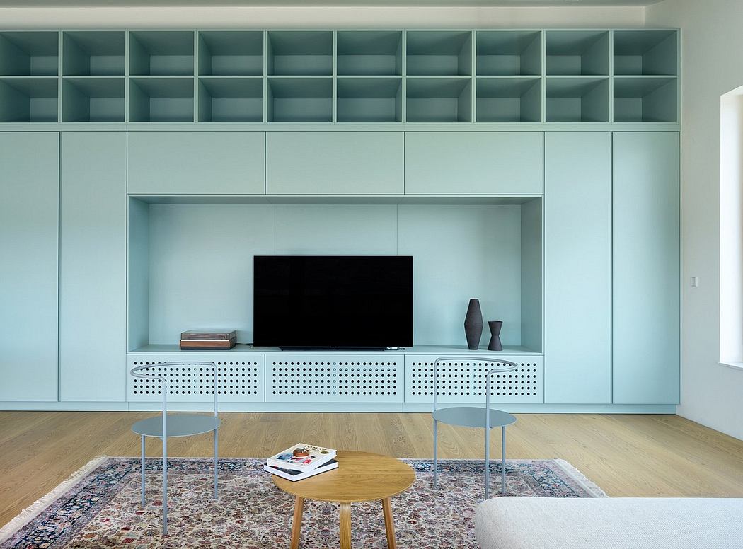 Sleek, minimalist shelving system with integrated TV cabinet and modern furnishings.