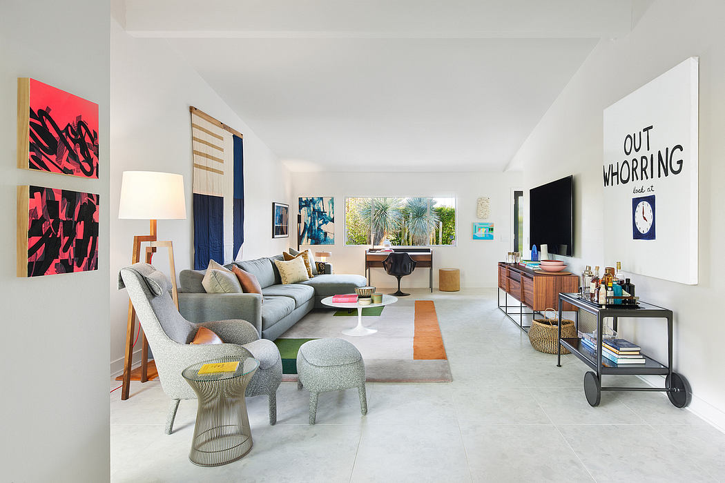 Chic open-plan living room with modern furniture and colorful artwork on walls.