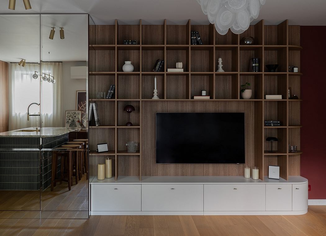 Sleek, modern interior with wood-paneled wall shelving, TV, and kitchen appliances.