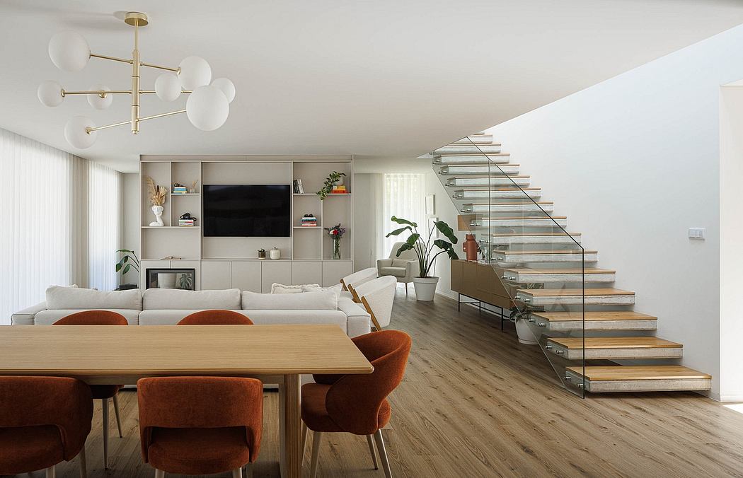 Sleek, minimalist open-plan living area with glass staircase and built-in shelving.