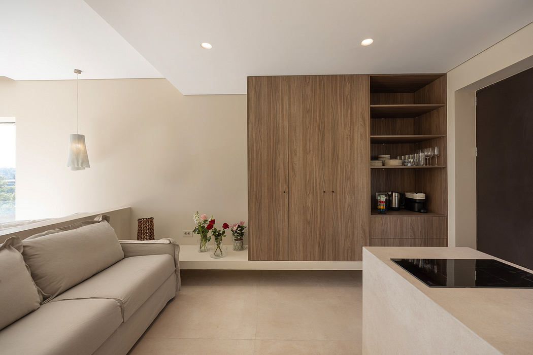 Warm-toned living space with recessed lighting, built-in storage, and a sleek kitchen counter.