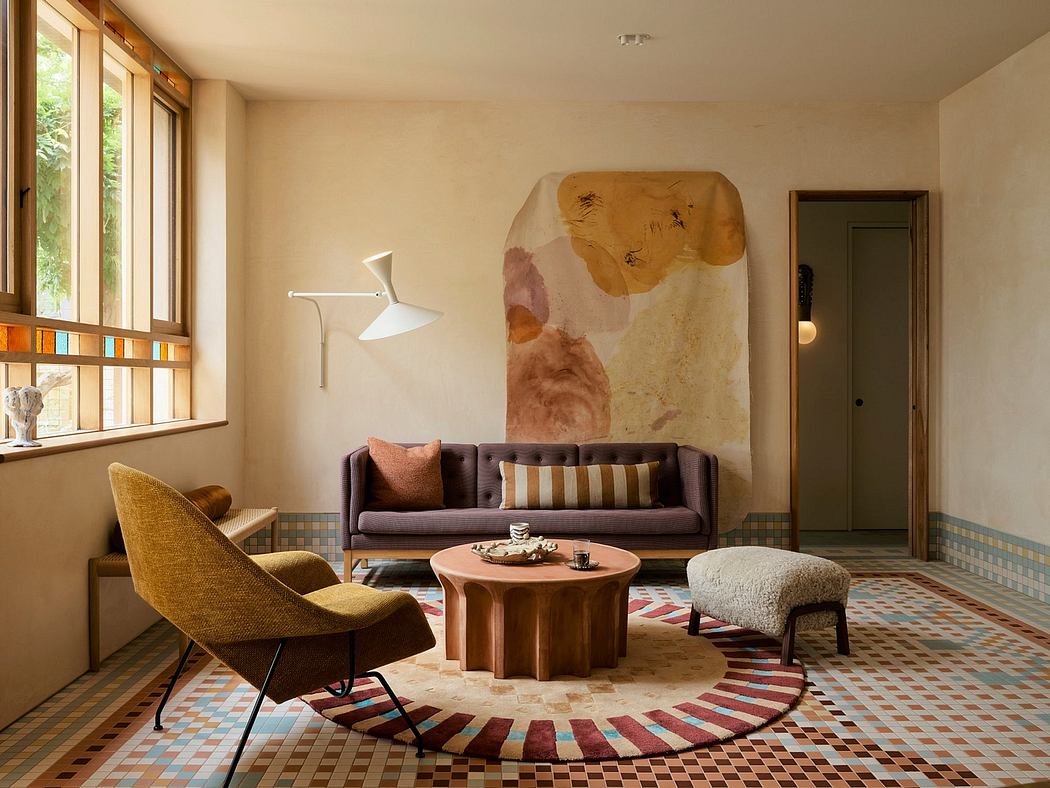 Warm-toned living space with abstract artwork, patterned tile flooring, and eclectic furnishings.