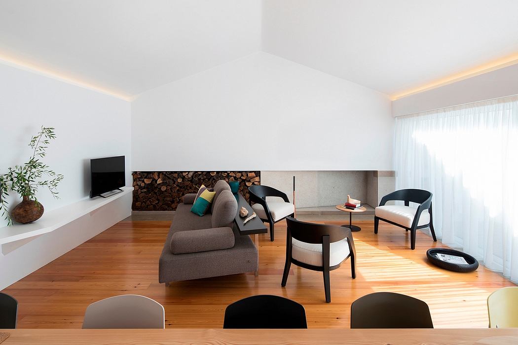 Modern, minimalist living room with wood paneling, plush seating, and wooden floors.