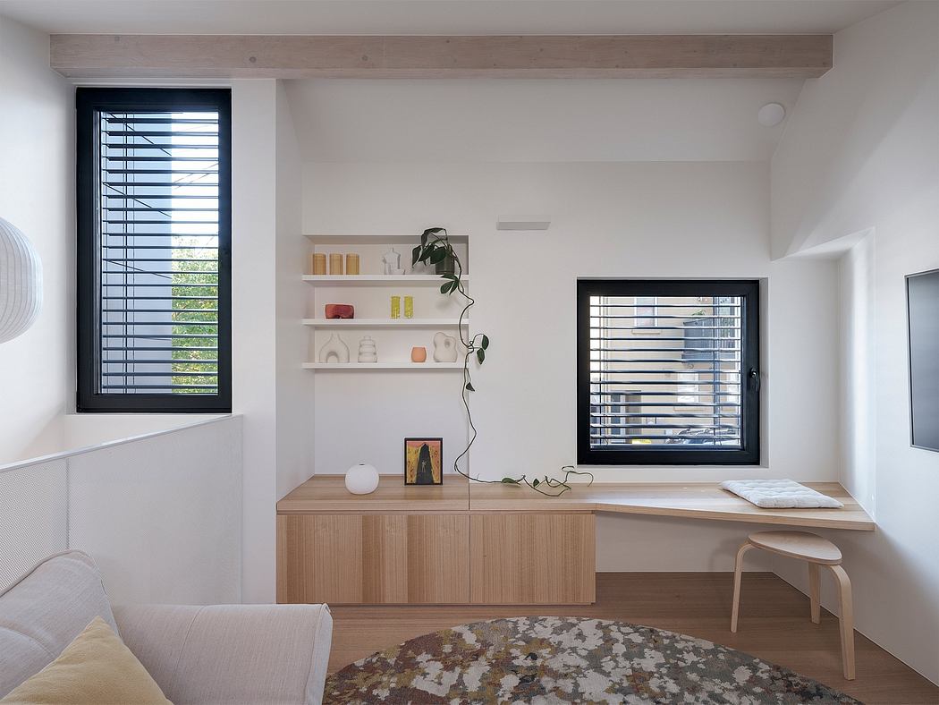 Minimalist interior with wooden beams, built-in shelving, and large windows providing natural light.