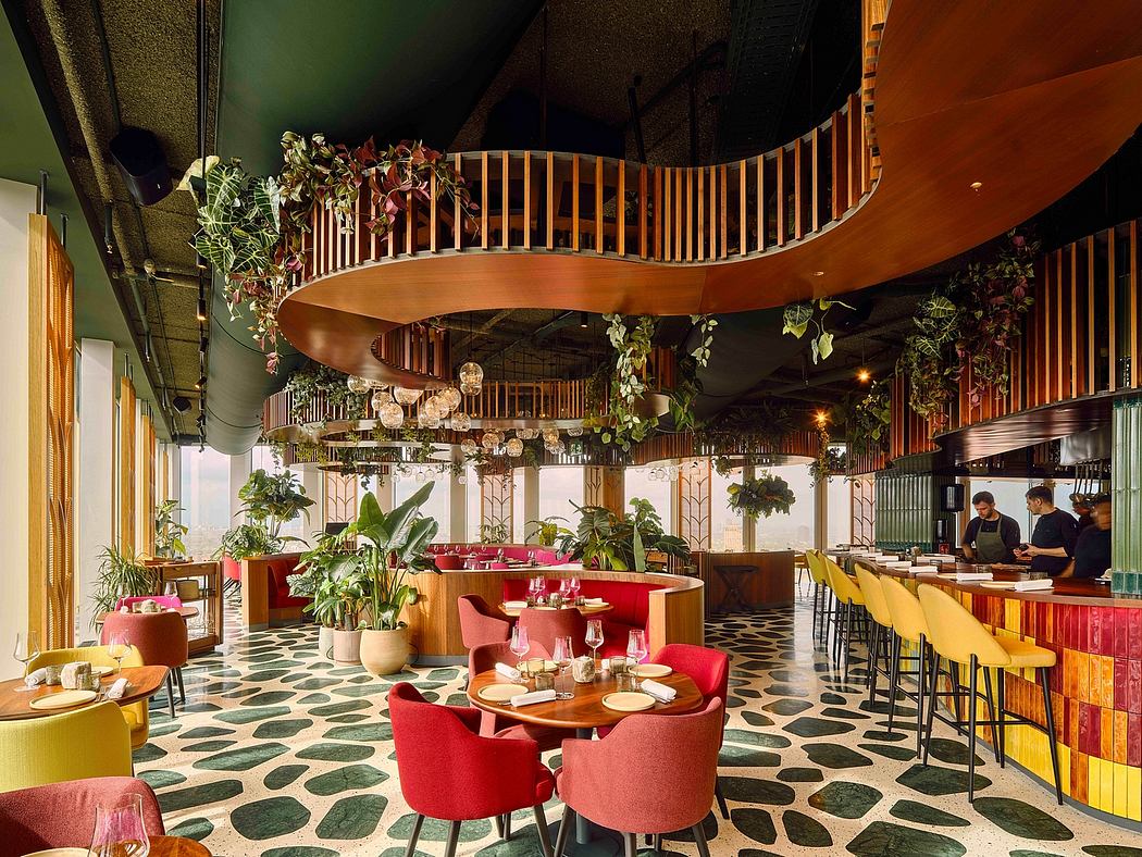 Vibrant, eclectic restaurant design with wooden spiral staircase, hanging plants, and patterned floor.