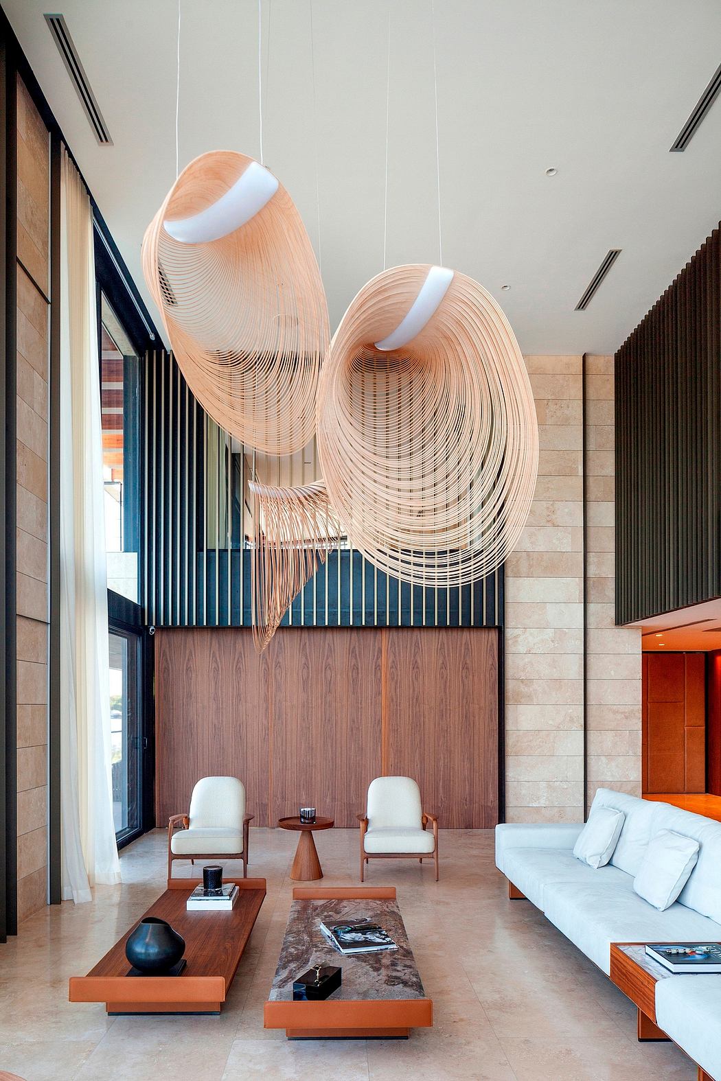 Dramatic suspended lighting fixtures and modern, textured furnishings create a stylish, inviting space.